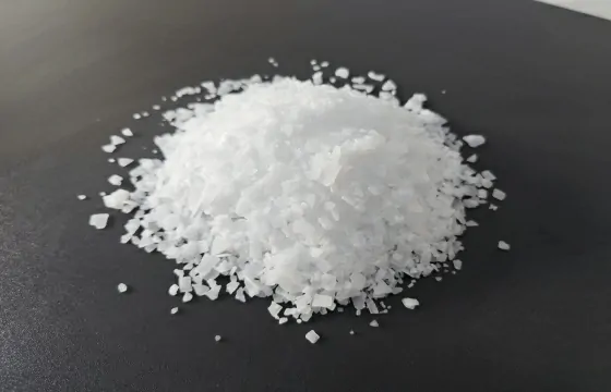  黑色底板上一小堆白色氢氧化钾晶体。